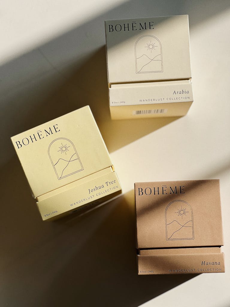 Aesthetic arrangement of Boheme candle boxes with shadows on a neutral background.