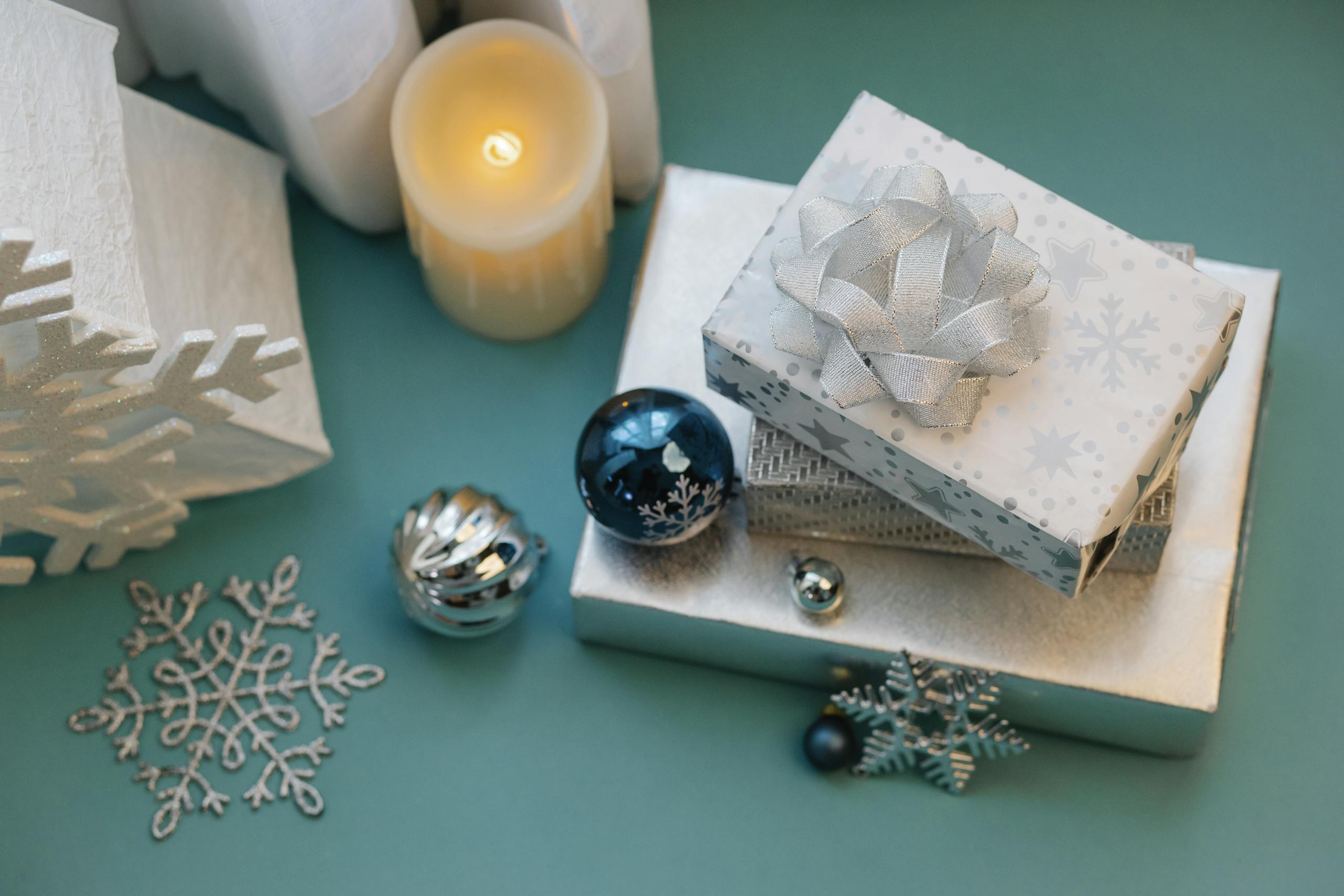 Christmas-themed photo with gifts, candle, and snowflake decorations.