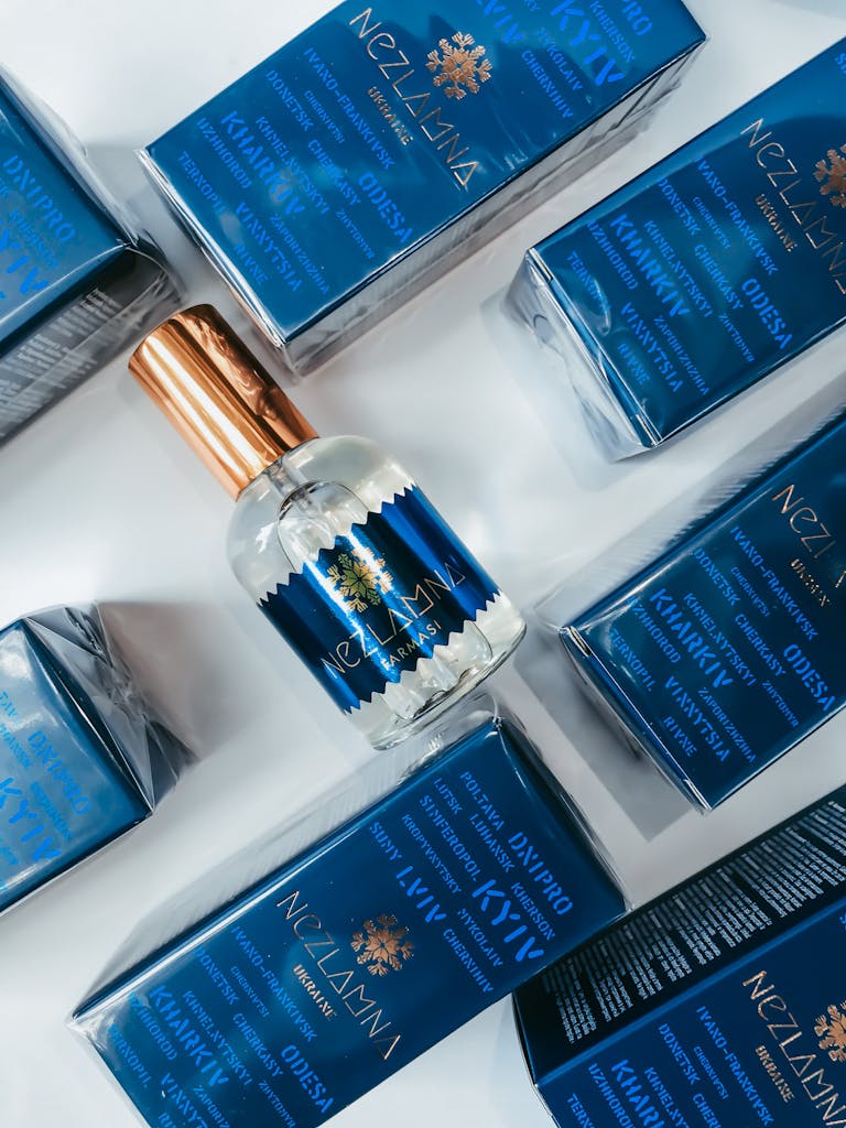 Close-up of an elegant blue perfume bottle surrounded by matching boxed packaging, highlighting luxury and beauty.