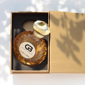 Luxurious perfume bottle in golden black packaging, elegant design.